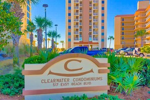 Schild für Clearwater Condominiums mit freiem Blick auf die Architektur des Gebäudes und die umliegende Bepflanzung.