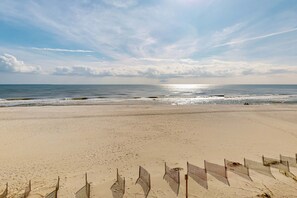 Ein Strand mit einem Zaun im Vordergrund und dem Meer im Hintergrund.