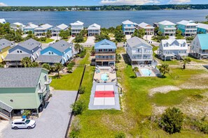 Un quartier résidentiel situé sur la côte, composé de plusieurs maisons à deux étages, d’une piscine et offrant une vue sur la mer.