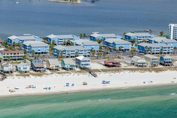 A coastal hotel with multiple blue buildings, a beach, and a pier. - Cheerful Condo with Shared Pool, Pier, and Beach Access (Gulf Shores)