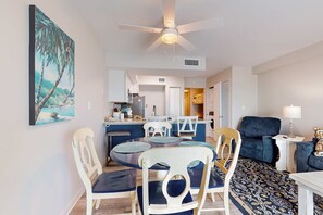 A dining area with a round table, chairs, and a ceiling fan. - Gorgeous Beach Home Overlooking the Beach w/Free WiFi, Central AC, Shared Pool and Covered Parking (Gulf Shores)