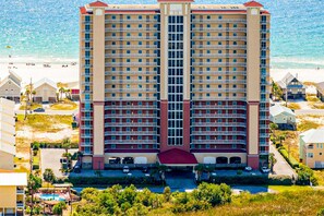 A multi-story hotel with a central entrance, balconies, and a view of the beach. - Wonderful Gulf Shores Home with Fantastic Water Views, Free WiFi, Shared Pool,Sauna (Gulf Shores)