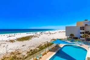Un espace piscine offrant une vue sur la plage et l’océan.