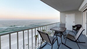 Ein Balkon mit Blick aufs Meer, einem Tisch und zwei Stühlen.