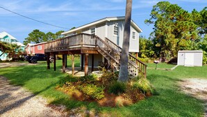 Ein Haus mit einer Holzterrasse, einer Treppe und einer Garage.