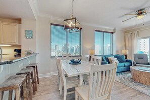 Eine moderne Küche mit Essbereich, einem blauen Sofa und Blick auf die Stadt.