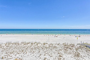 A beach with white sand, a clear blue sky, and the ocean in the background. - Amazing Condo in Gulf-Front w/Free WiFi, Shared Pool & Hot Tub, Central AC (Orange Beach)