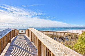 A wooden boardwalk leading to a beach with a clear sky. - Splendid beachfront condo with pool, tennis court, sauna, & WiFi (Orange Beach)