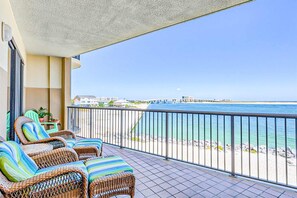 Ein Balkon mit Korbmöbeln und Blick auf den Strand.