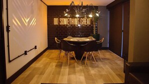A modern dining area with a neon sign that reads "DO SOMETHING GREAT" on the wall, a round table with chairs, and a ceiling-mounted light fixture. - Park Del Prado #603 - Intermares by Carpediem (Cabedelo)