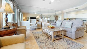 Un salón amplio con sofá, sillones, una mesa de centro y zona de comedor.