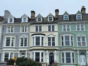 A row of Victorian-style townhouses with bay windows and dormer windows. - Sea View, East Parade (Llandudno)