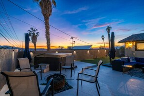 An outdoor patio with seating, a fire pit, and a view of the sunset. - Havasu Pool Home | Spa, Games & Boat Parking (Lake Havasu City)