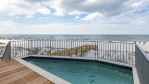 A pool with a wooden deck, a metal railing, and a view of the beach and ocean. - Luxury Gulf-front home w private splash pool & direct beach access (Orange Beach)