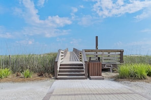 A wooden boardwalk leading to a wooden structure with a chimney, surrounded by tall grasses and a clear sky. - Family-friendly beach home w Gulf views, a full kitchen, & spacious living area (Orange Beach)