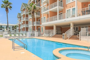 Ein Hotel mit Swimmingpool, Balkonen und Palmen.