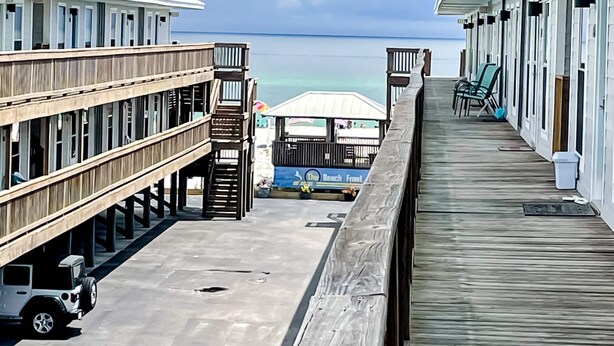 Un muelle de madera que conduce a un hotel frente al mar, con vista al océano.
