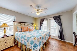A bedroom with a bed, a ceiling fan, a nightstand, a lamp, and a window with blinds. - Direct Lagoon Front Home w/ Shared Pool, Free WiFi, Central A/C, & Water Views (Gulf Shores)