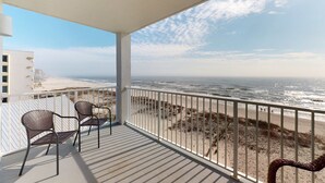 A balcony with a view of the beach, two chairs, and a railing. - Amazing Condo in Gulf-Front Condo Featuring a Shared Pool, Free WiFi, Central AC (Gulf Shores)