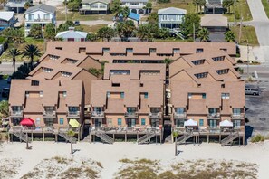 A beachfront hotel with multiple balconies, a sandy beach in front, and a parking area. - Multi-Level, Beachfront Condo w/ Gulf Views, Deck, WiFi, AC & Shared Pool (Gulf Shores)