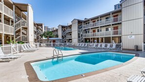 Un hôtel doté d’une piscine, de plusieurs balcons et d’une zone de piscine clôturée.