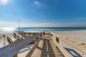A wooden boardwalk leading to a beach with a clear sky and calm sea. - Gulf-front condo with panoramic views, balcony & shared pool, hot tub, gym (Gulf Shores)