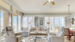 Ein geräumiges Wohnzimmer mit großem Fenster, Deckenventilator und Essbereich.