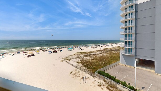 Vista de playa con un edificio, arena y océano.