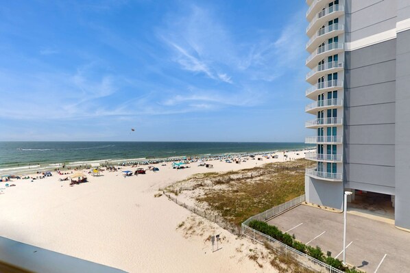 A beach view with a building, sandy beach, and ocean. - Beachfront condo with pool, private balcony, & washer and dryer (Gulf Shores)