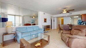 Una sala moderna con un sofá, una mesa de centro y un comedor con sillas y una mesa.