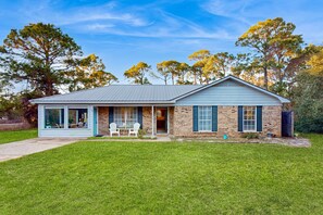 Einbungalow mit Veranda, Ziegelaußenwand und gepflegtem Rasen.