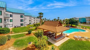 A hotel with a swimming pool, outdoor seating, and a covered pavilion. - Pool view studio with onsite sauna, beach access, and pickleball courts (Gulf Shores)