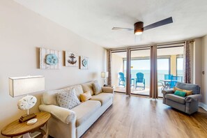 A living room with a sofa, a smaller couch, a side table, and a ceiling fan. - Dreamy beach condo with water views, balcony, pool & beach access (Orange Beach)
