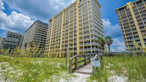 A multi-story hotel with balconies, a beach view, and a sign indicating it is a summer house for guests. - Dreamy beach condo with water views, balcony, pool & beach access (Orange Beach)
