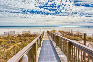 A wooden boardwalk leading to a beach with a clear sky. - Beachfront condo with pool, tennis court, hot tub & central AC (Orange Beach)