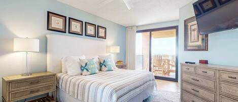 A bedroom with a bed, nightstands, a dresser, a ceiling fan, and a TV.