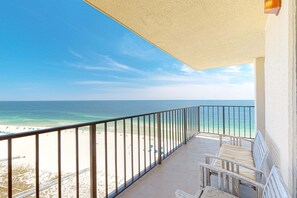Un balcon avec vue sur une plage et l’océan.