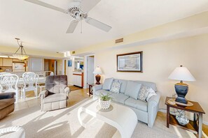 A living room with a sofa, armchairs, a coffee table, and a dining area with chairs and a table. - Beachfront Views Beside Perdido Pass (Orange Beach)