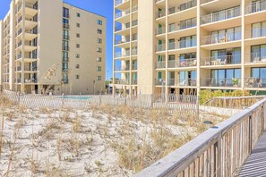 A multi-story hotel with balconies, a pool area, and a wooden deck. - Beautiful resort condo at the foot of the beach with pool, WiFi, central AC (Orange Beach)