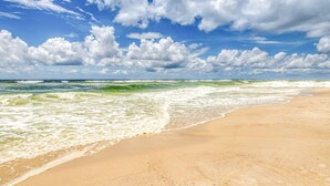 A beach with waves, a clear sky, and clouds. - Seaside escape with balcony, WiFi, pools, tennis, steam room, & gym (Orange Beach)