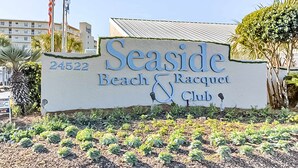 A sign for Seaside Beach & Racquet Club with a number 24522. - Seaside escape with balcony, WiFi, pools, tennis, steam room, & gym (Orange Beach)