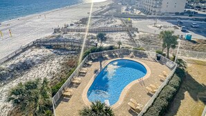 A resort with a swimming pool, beach access, and a high-rise building in the background. - Seaside escape with balcony, WiFi, pools, tennis, steam room, & gym (Orange Beach)