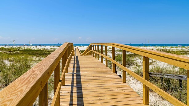 A wooden boardwalk leading to a beach with sand dunes and a clear blue sky. - Gulf-Front Condo w/ Balcony, Shared Pools, and Beach Access (Dauphin Island)