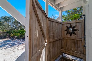 A wooden structure with a star-shaped decoration, a bench, and a view of the beach. - Spacious private home with patio, balconies, close to beaches (Gulf Shores)
