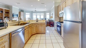 Une cuisine spacieuse dotée de meubles en bois, d’appareils électroménagers en acier inoxydable et d’un îlot central.