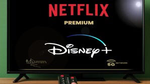 Un televisore mostra l'interfaccia Netflix Premium Disney+ con un telecomando in mano.