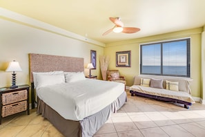 A bedroom with a bed, a nightstand, a chair, a window, and a ceiling fan. - Gulf-front 6th-floor condo with balcony, pool, hot tub, & sauna - beach access (Orange Beach)