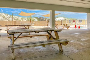 A covered outdoor area with picnic tables and a view of dunes. - Gulf Front Getaway w/ Free WiFi, Central A/C, Balcony, Shared Pool, Beach Access (Orange Beach)
