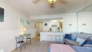 A hotel room with a bed, a small table with chairs, a kitchenette, and a sofa. - Updated studio w/shared outdoor pools and tennis court, family-friendly, & more! (Orange Beach)