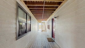 A corridor with wooden flooring, white walls, and a wooden ceiling. - Condo with partial Gulf views, shared outdoor pool, sun deck & private beach access (Orange Beach)